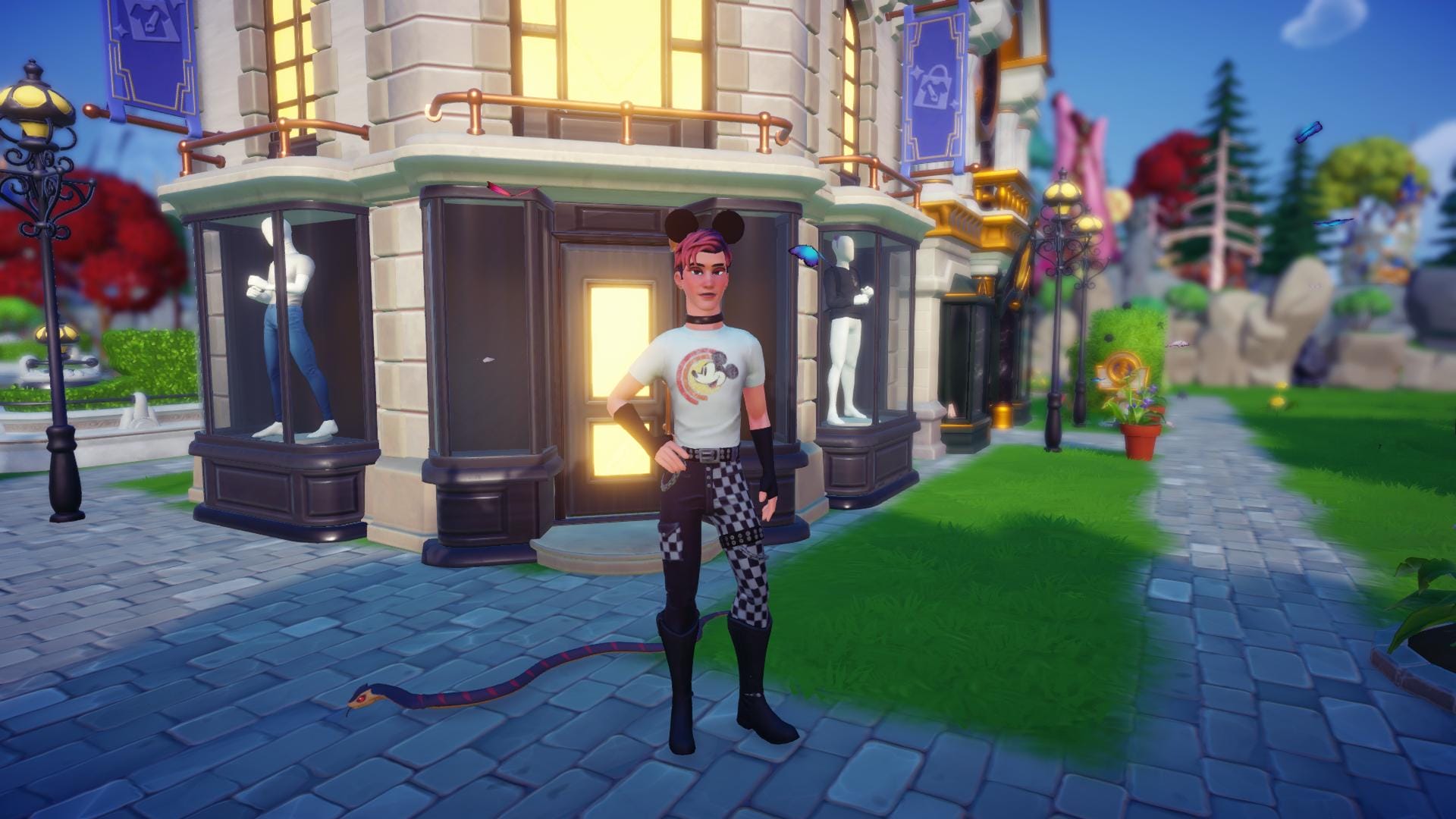 The player character showing his outfit off, standing in front of Daisy's Fashion Boutique. His hair has blue roots and his bangs are coral pink. He is wearing a white t-shirt with a vintage Mickey graphic, leather pants which are half black, half checkered, with a spiky band around one of his legs. His black boots are almost up to his knees. He's wearing a solid black choker arond his neck and black fingerless gloves which almost reach his elbows.